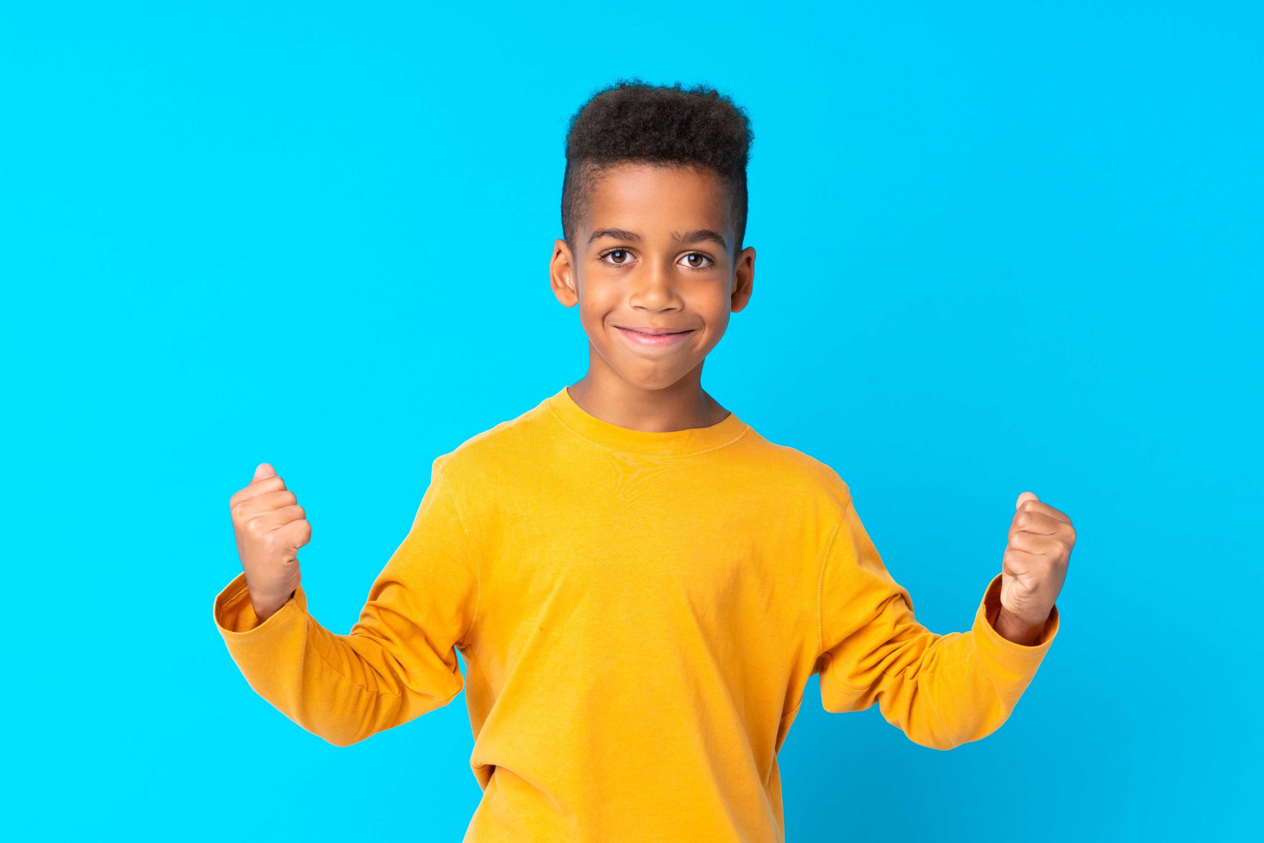 African American boy over isolated blue background celebrating a victory